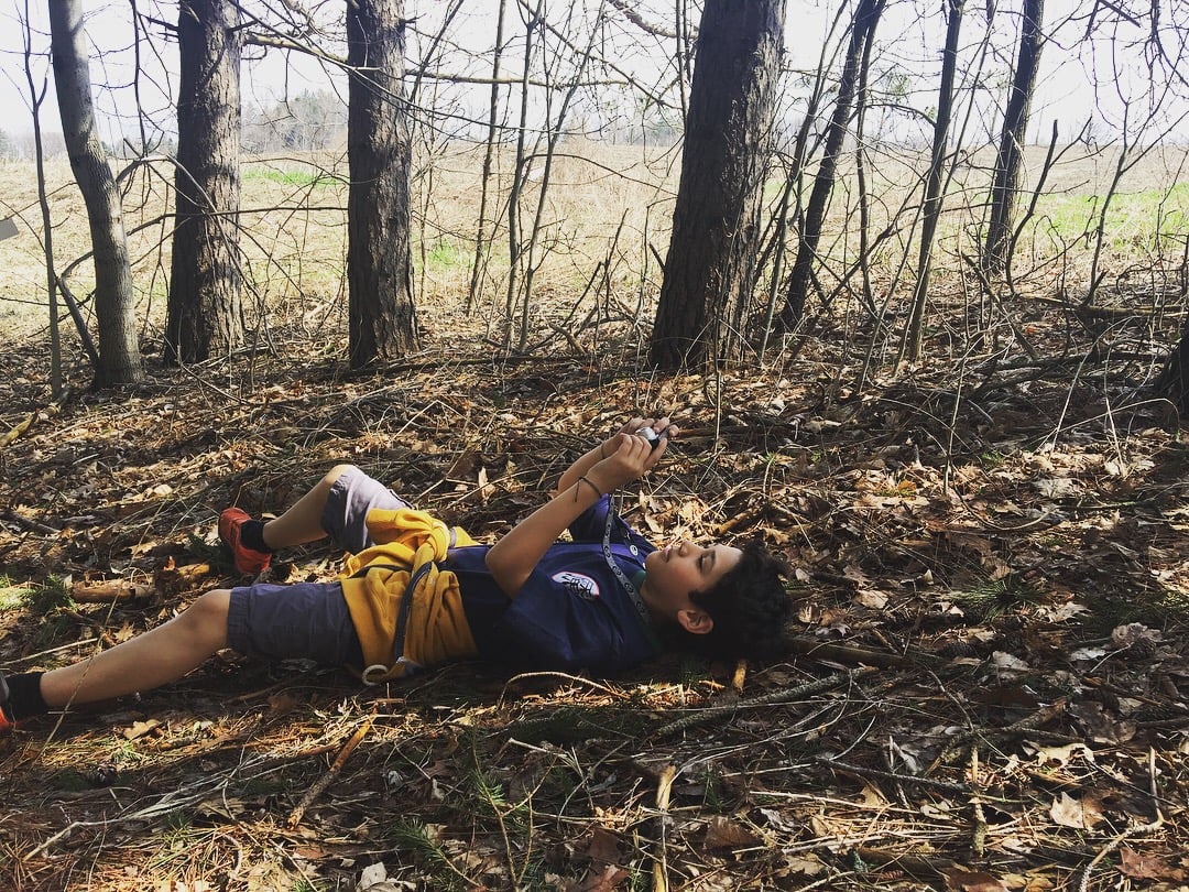 Student relaxing in the woods