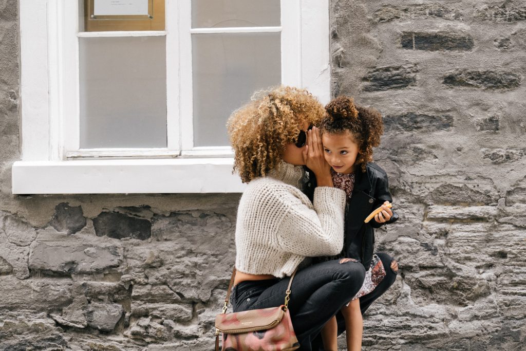 Mom whispering to daughter