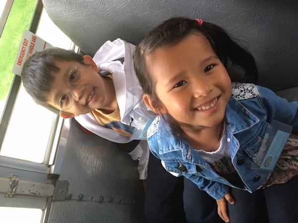 Students smiling on the bus