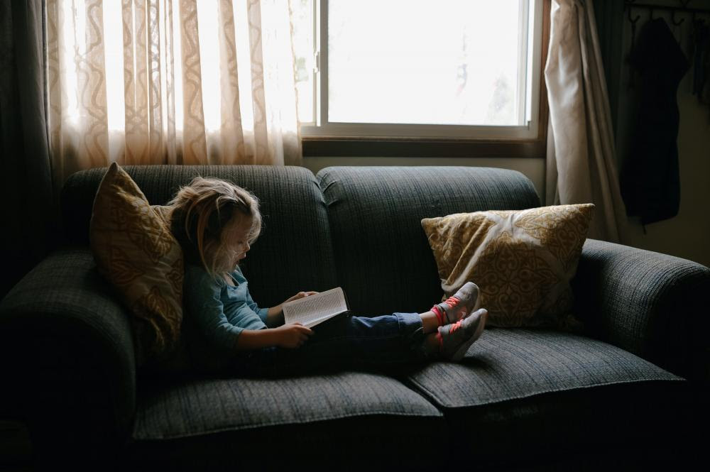 Child reading on couch