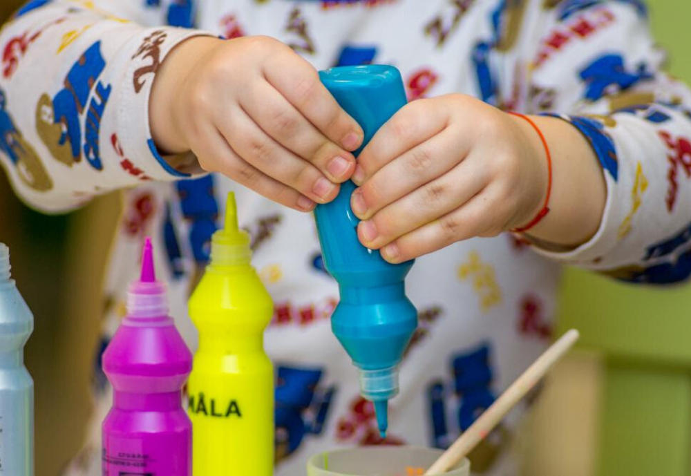 Child with Paint Bottles