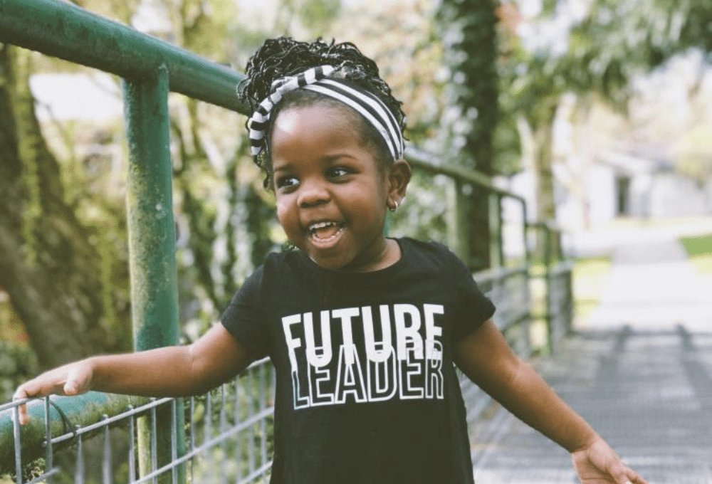 Young child with shirt that reads "future leader"