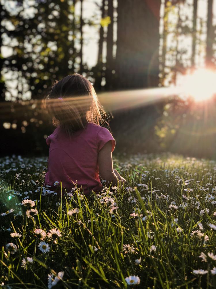 Child sitting in flowers