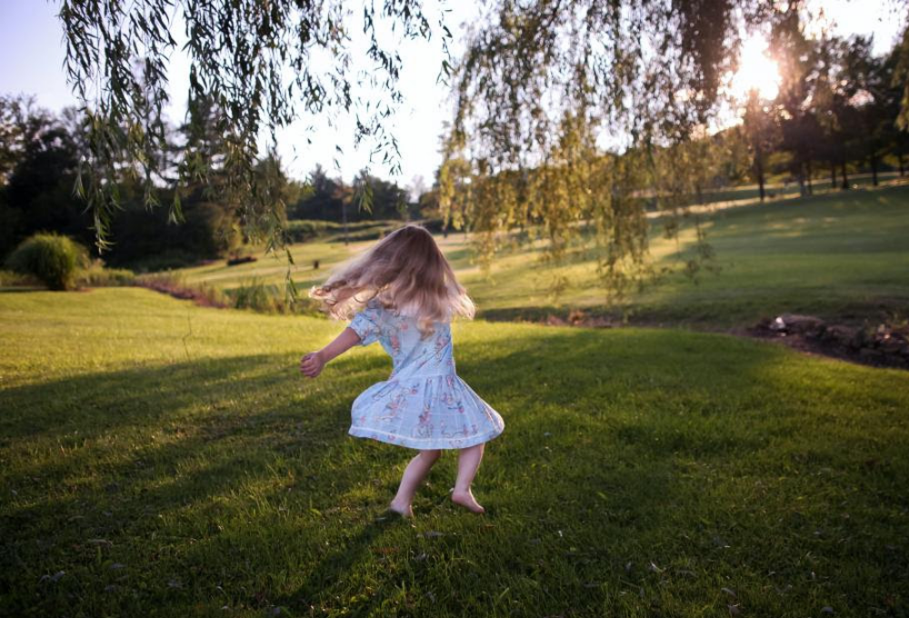 Child dancing on the grass