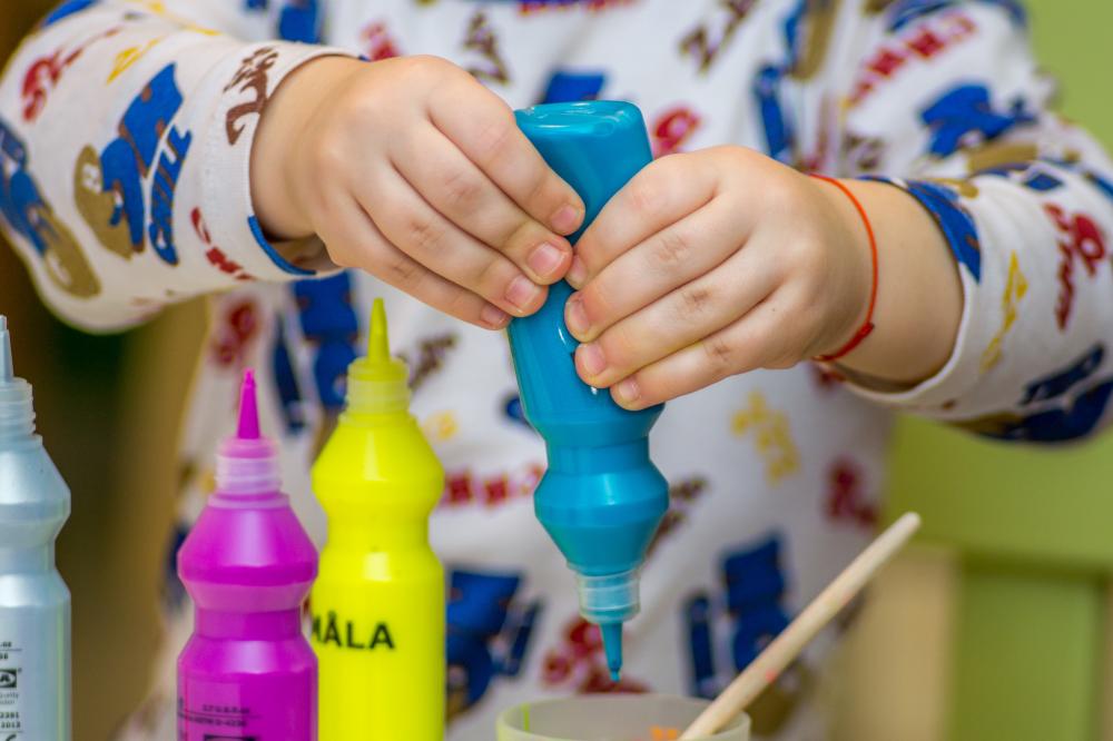 Child with paint bottles