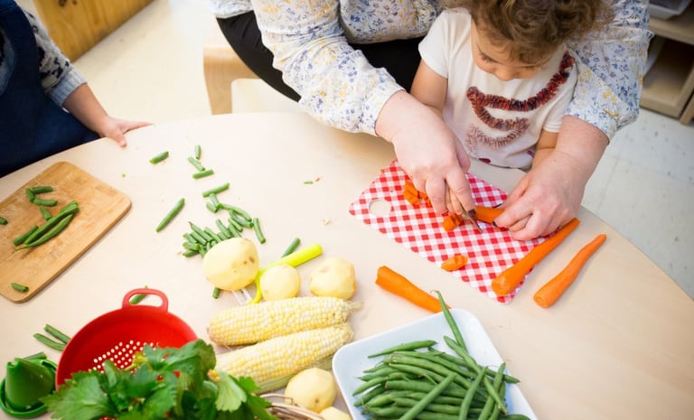 Students chopping veggies with teacher